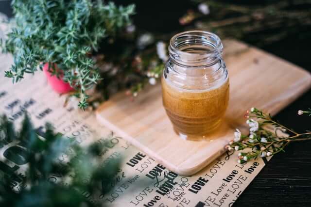 a jar of honey on a cutting board 
