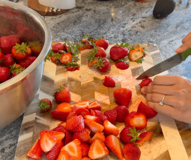 hand cutting strawberries in slices