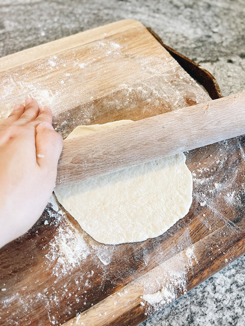 rolling out tortilla dough with rolling pin
